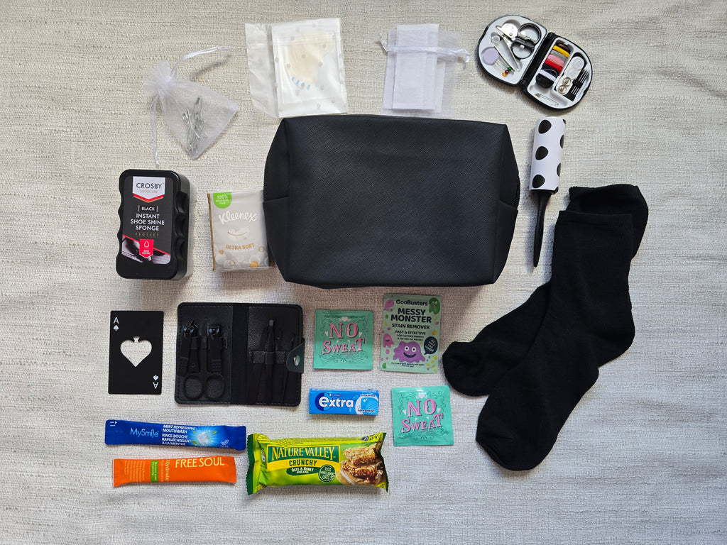Groom emergency kit contents laid out including manicure kit, sewing kit, black socks, lint roller, shoe shine sponge and grooming essentials for wedding day